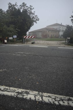 Malikane ve ahırı, sonbaharda İtalya 'nın kırsalında sisli bir günde ağaçlarla kaplı.