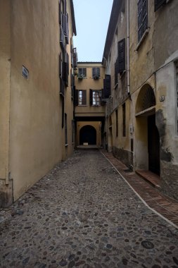 İtalya 'da bulutlu bir günde binalar arasında dar bir ara sokak.