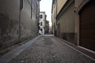 İtalya 'da bulutlu bir günde binalar arasında dar bir ara sokak.