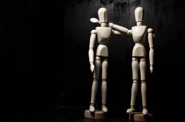 Kameraya poz veren iki tahta heykel birbirine yakın duruyor.