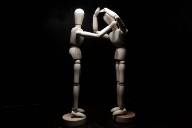 Bir tahta heykel diğerini rahatlatıyor.