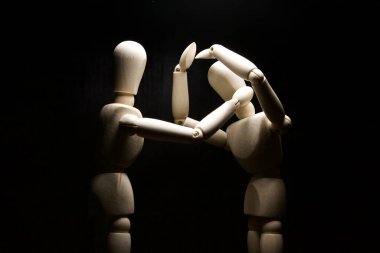 Bir tahta heykel diğerini rahatlatıyor.