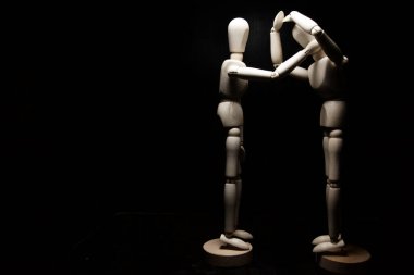 Bir tahta heykel diğerini rahatlatıyor.