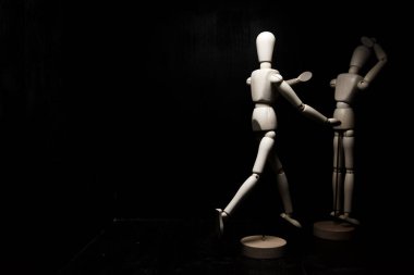 Bir tahta heykel diğerini rahatlatıyor.