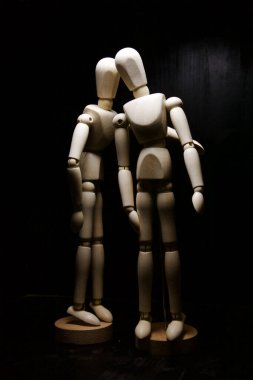 Bir tahta heykel diğerini rahatlatıyor.