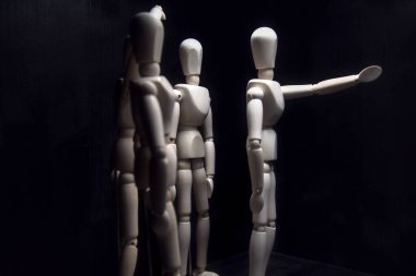 Figürler bir şey arıyormuş gibi davranıyorlar ve biri bir şeyi işaret ediyor.