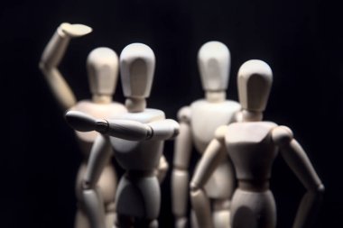 Figürler bir şey arıyormuş gibi davranıyorlar ve biri bir şeyi işaret ediyor.