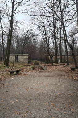 Sonbaharda bir duvarın yanında taştan bankları olan bir hendek ve bir duvarın yanında taşlaşmış bir meydan.