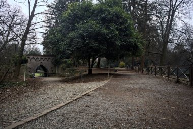 Sonbaharda parktaki tuğla köprünün altından geçen çakıl yolu.