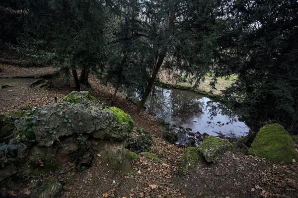 Sonbaharda bir parkta küçük bir şelalenin dibinde.