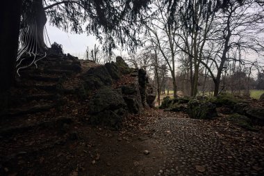 Sonbaharda bir parkta kaya oluşumuyla çevrelenmiş bir patika.