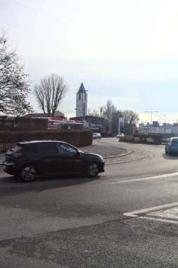 İtalyan kırsalındaki bir köyde çan kulesi ve benzin istasyonu olan bir kavşak.