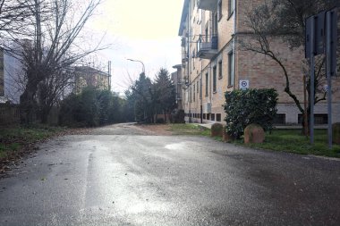 Yağmur yağdıktan sonra bir binanın arkasındaki demiryolunun yanındaki sokakta.