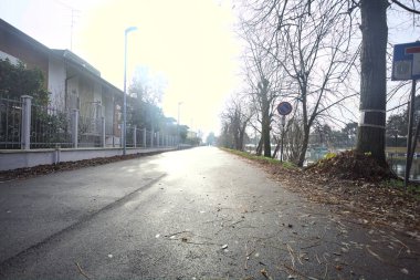 Evlerin yanında bir sokak ve İtalya kırsalında bir körfez.