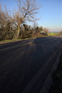 Çıplak ağaçlarla çevrili köy yolu