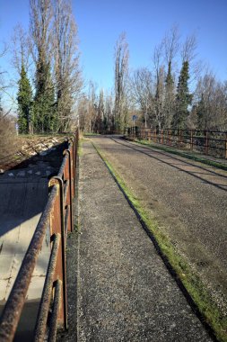 Toprak bir patikayla köprü arasındaki yol ayrımı