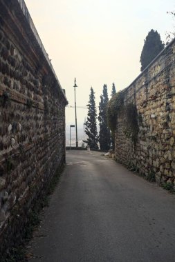 Taş duvarlarla çevrili dar bir sokak.