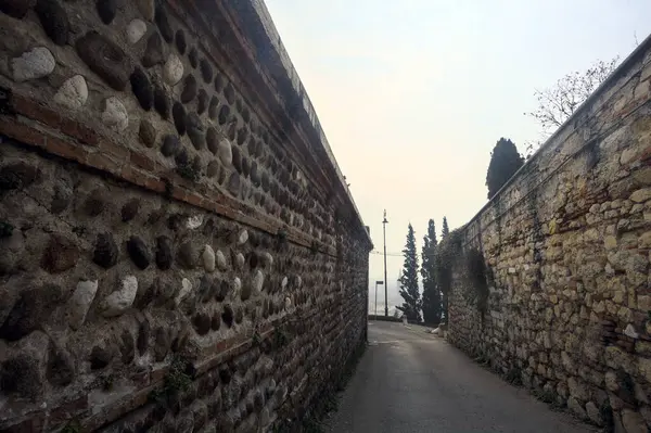 Narrow street bordered by stone walls