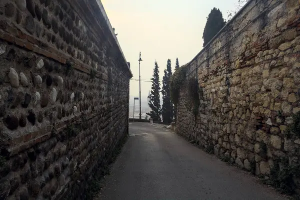Narrow street bordered by stone walls
