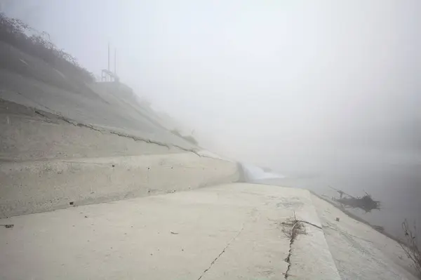 Embankment in a diversionary channel in the fog