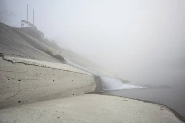 Embankment in a diversionary channel in the fog