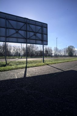 Bir reklam panosunun arkasındaki köy yolu.