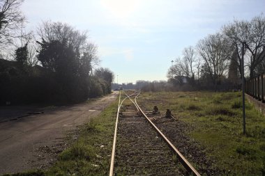 Abandoned railroad tracks next to a warehouse clipart