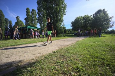 Kırsal bir panayırda insanlar parkta geziniyor.