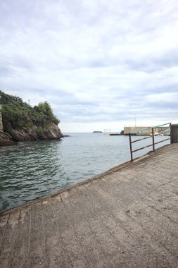 Deniz kıyısında beton bir dalgalanma ile çevrili körfez.