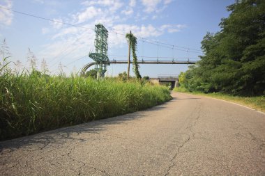 Bir köy yolunun üzerinden geçen boru hattı
