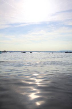 Tekneleri ve yüzen insanları olan göl.