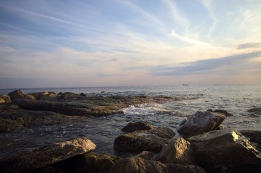 Gün batımında dalgalı su taşları