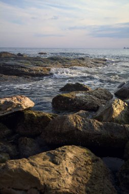 Gün batımında dalgalı su taşları