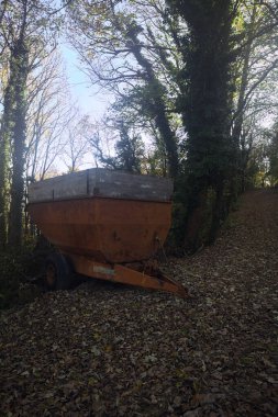 Trailer of a tractor in a forest clipart