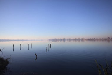 Göl kıyısında tahta direkler.