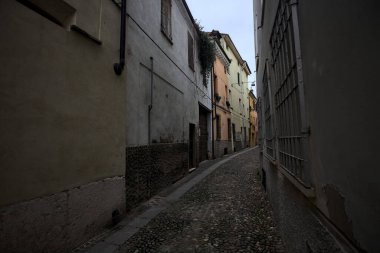 Gölgede çok dar kaldırımlı bir sokak.