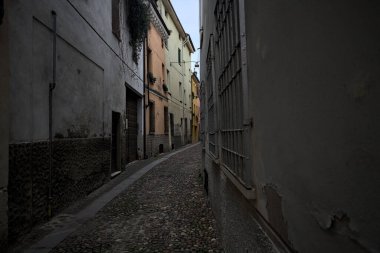 Gölgede çok dar kaldırımlı bir sokak.