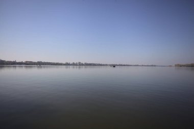 Güneşli bir günde gölde yüzen tekneler çok uzaklardan görülüyor.