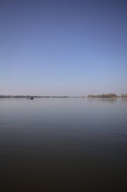 Güneşli bir günde gölde yüzen tekneler çok uzaklardan görülüyor.