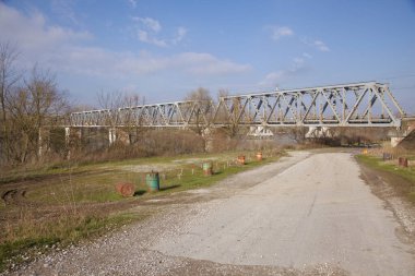 İtalya 'nın kırsal kesimlerinde kıyısından geçen bir nehirde demiryolu köprüsü görülüyor.