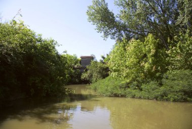 Güneşli bir günde, İtalya 'nın kırsal kesimlerinde ağaçların ve gökyüzünün olduğu bir nehrin körfezi.