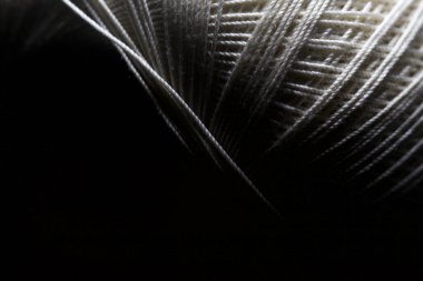 Yakından görülen siyah bir arkaplanda iplik dikiyorum