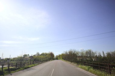 İtalya kırsalında yol ve köprü güneşli bir günde kısmen güneşe karşı aydınlık