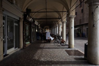 Mantova, İtalya - 22 ND APRIL 2025 - Dükkanların ve insanların geçtiği gölgede kısmen veranda
