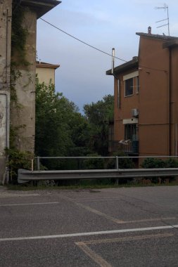 Gün batımında bir İtalyan köyünün yakınındaki derenin üzerinden geçen yol köprüsü.