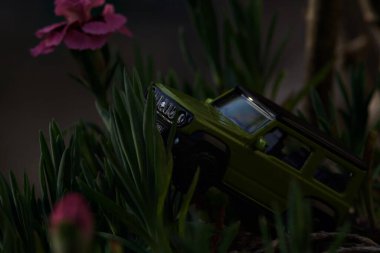 Mantova, İtalya - 27 Nisan 2025 - 1 / 64 Majorette kopyası çiçek açan karanfil vazosundaki Suzuki Jimny