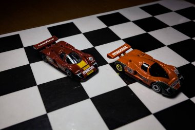 Mantova, İtalya - 29th APRIL 2025 - 1 / 64 Hot Wheels replicas of two Mazda 787B on a ışıltılı kontrol edilmiş folyo simülasyon simülasyonu
