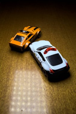 Mantova, İtalya - 29 Nisan 2025 - 1 / 64 Hot Wheels and Takara Tomi replicas of a orange Nissan Fairlady Z and a Nissan Fairlady Z Nismo Japanese police car simulating a ramming