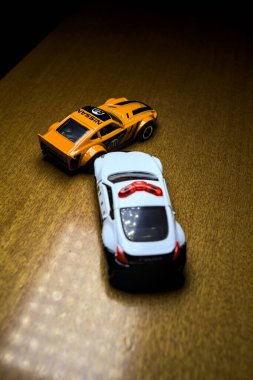Mantova, İtalya - 29 Nisan 2025 - 1 / 64 Hot Wheels and Takara Tomi replicas of a orange Nissan Fairlady Z and a Nissan Fairlady Z Nismo Japanese police car simulating a ramming