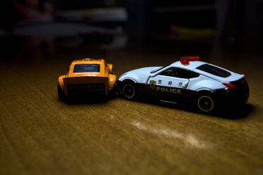 Mantova, İtalya - 29 Nisan 2025 - 1 / 64 Hot Wheels and Takara Tomi replicas of a orange Nissan Fairlady Z and a Nissan Fairlady Z Nismo Japanese police car simulating a ramming